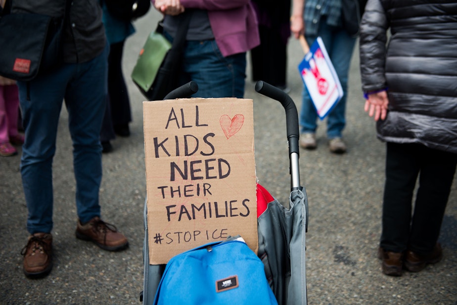 caption: A stroller was used to hold up a sign during the Solidarity Day protest outside of the Federal Detention Center in SeaTac.