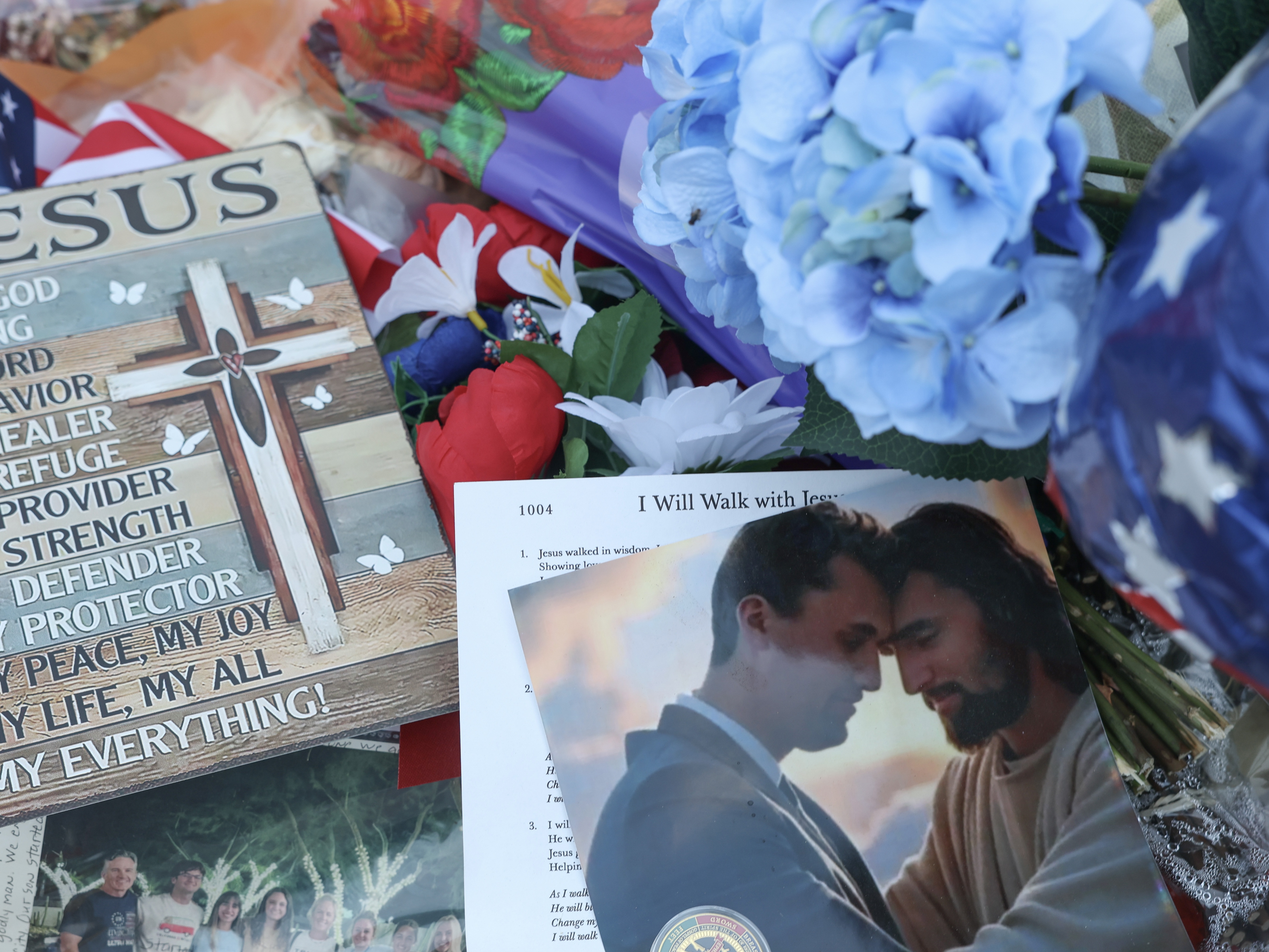 caption: Items are displayed in the makeshift memorial for Charlie Kirk outside the headquarters of Turning Point USA on Thursday in Phoenix.