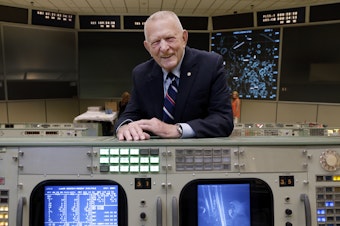 caption: Gene Kranz stands behind the console at Mission Control in Houston where he worked during the Gemini and Apollo missions.