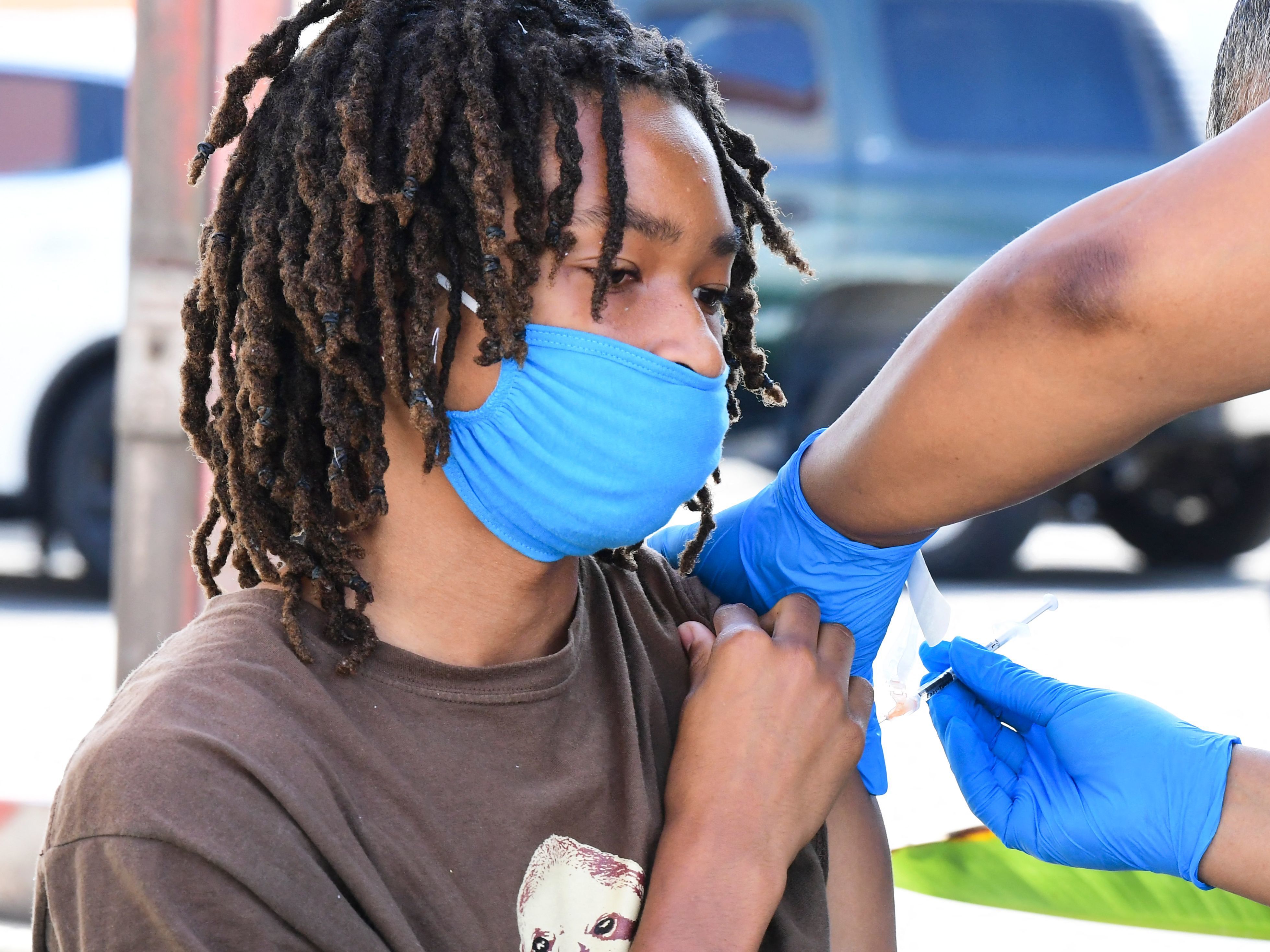 caption: Jacob Alexander, 14, receives her Pfizer Covid-19 vaccine at a mobile vaccine clinic hosted by Mothers in Action and operated by the Los Angeles County of Public Health on July 16. COVID-19 cases across America are rising in all 50 states as the Delta variant spreads with about half the US population yet to be fully vaccinated.