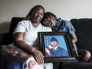 caption: Chantemekki Fortson, mother of Roger Fortson, a U.S. Air Force senior airman, holds a photo of her son.
