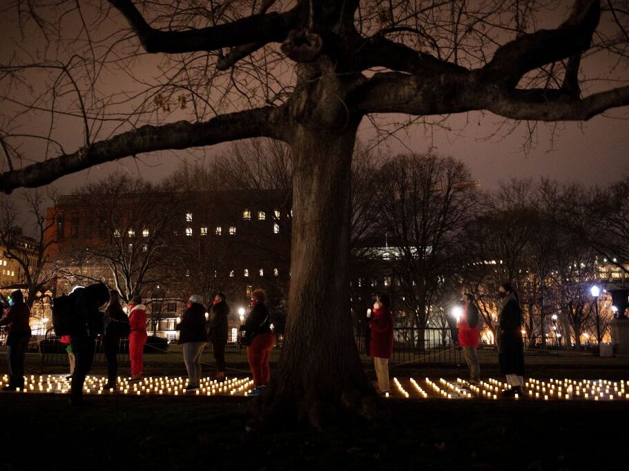 caption: Activists gather during a vigil in Lafayette Park for nurses who died during the COVID-19 pandemic on January 13, 2022, in Washington, DC. (Photo by Brendan Smialowski / AFP) (Photo by BRENDAN SMIALOWSKI/AFP via Getty Images)