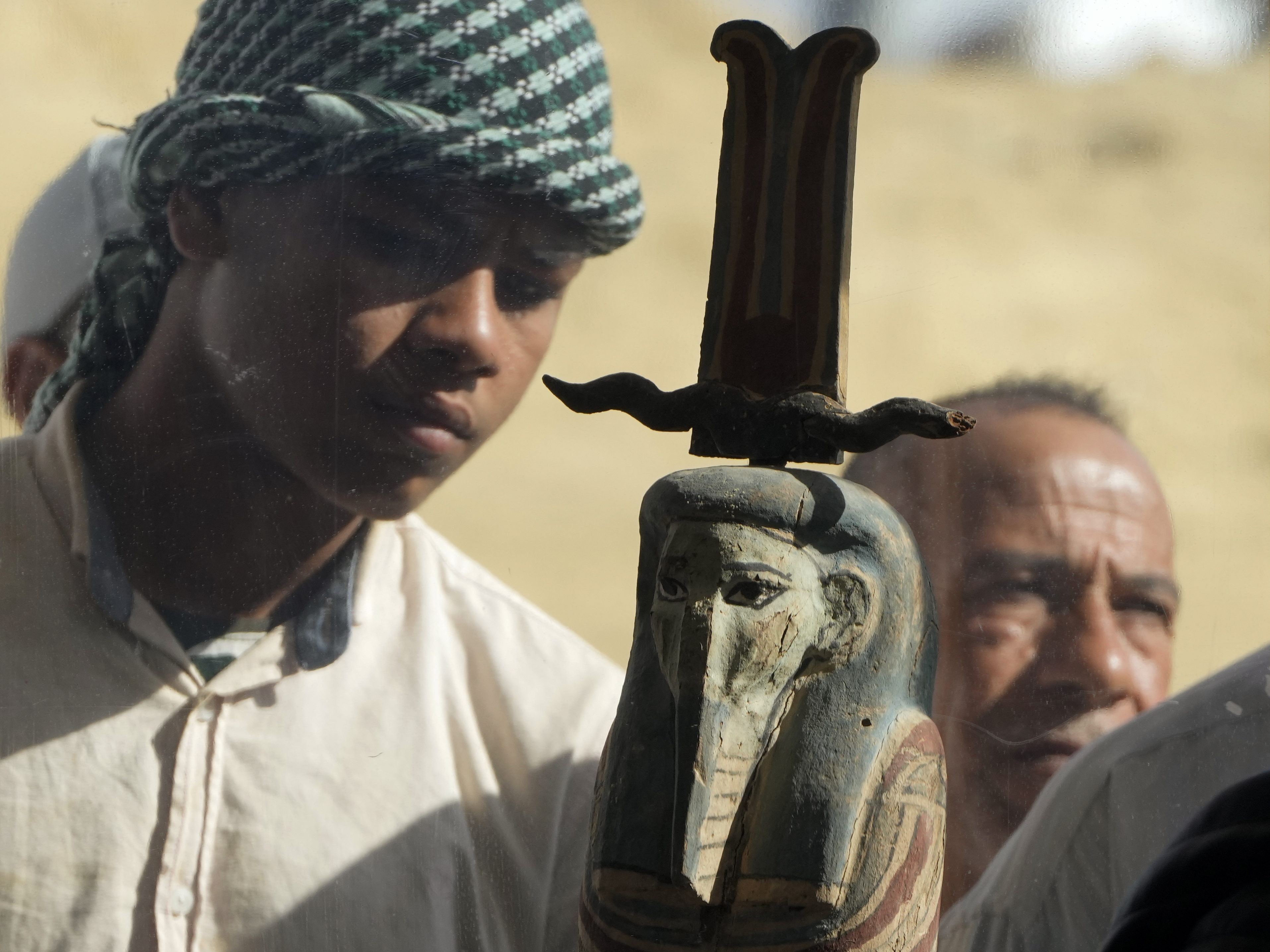 caption: An Egyptian antiquities worker watches a recently discovered artifact at the site of the Step Pyramid of Djoser in Saqqara, 24 kilometers (15 miles) southwest of Cairo, Egypt, Thursday, Jan. 26, 2023.