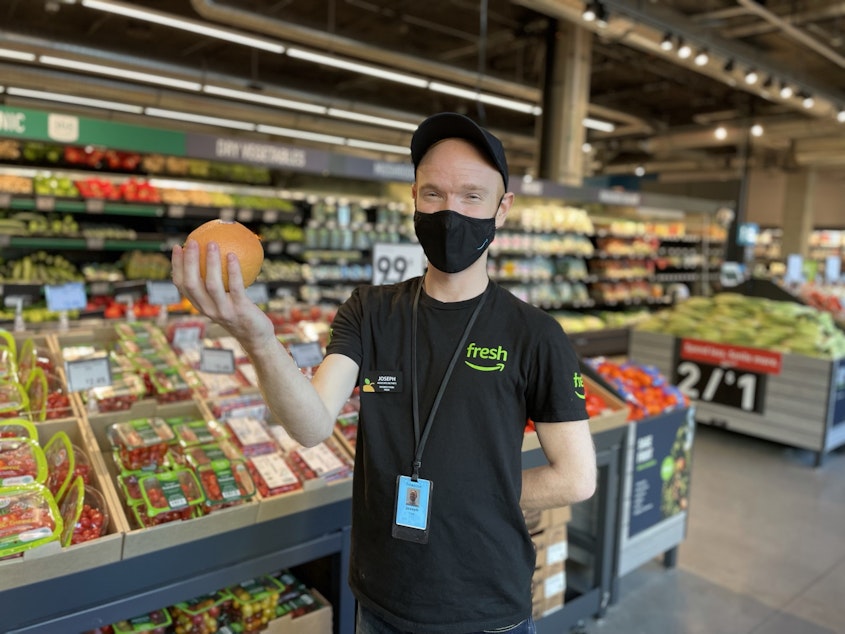 caption: Joseph Fink, an employee at Amazon Fresh at 23rd and Jackson and a member of the union Amazon Workers United, poses for a photo in September 2021.