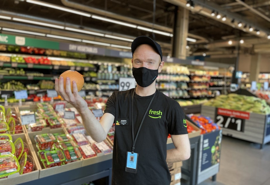 caption: Joseph Fink, an employee at Amazon Fresh at 23rd and Jackson and a member of the newly formed union Amazon Workers United, poses for a photo in September, 2021.