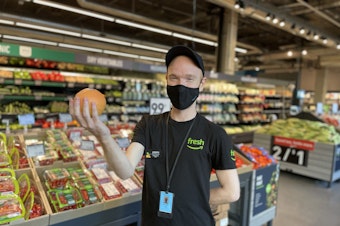 caption: Joseph Fink, an employee at Amazon Fresh at 23rd and Jackson and a member of the union Amazon Workers United, poses for a photo in September 2021.