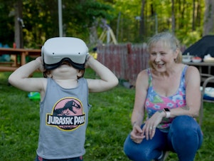 caption: Linda Munson's youngest grandson, Daniel Gomez, 2, tries on an Oculus headset in her yard in Berlin, Conn. Playing different virtual reality games has become her family's regular Sunday activity, Munson said.
