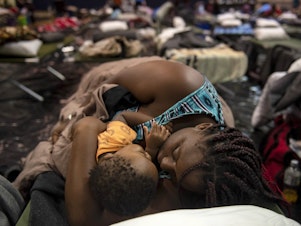 caption: A woman holding a child sleeps after being evacuated at Southeast Raleigh High School ahead of Hurricane Florence in Raleigh, N.C. on Wednesday.