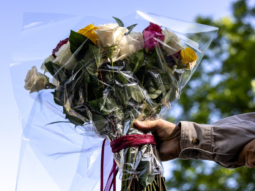 caption: A man brings flowers to Robb Elementary School on Wednesday in Uvalde, Texas.
