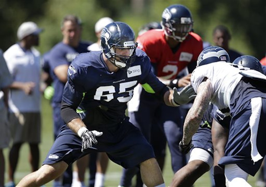 caption: New Seattle Seahawks Eric Winston (65) moves to block at the line of scrimmage at an NFL football camp practice Tuesday.