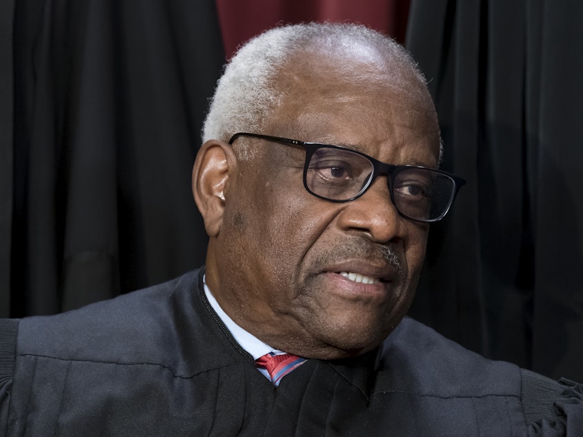 caption: Associate Justice Clarence Thomas joins other members of the Supreme Court as they pose for a group portrait on Oct. 7, 2022.