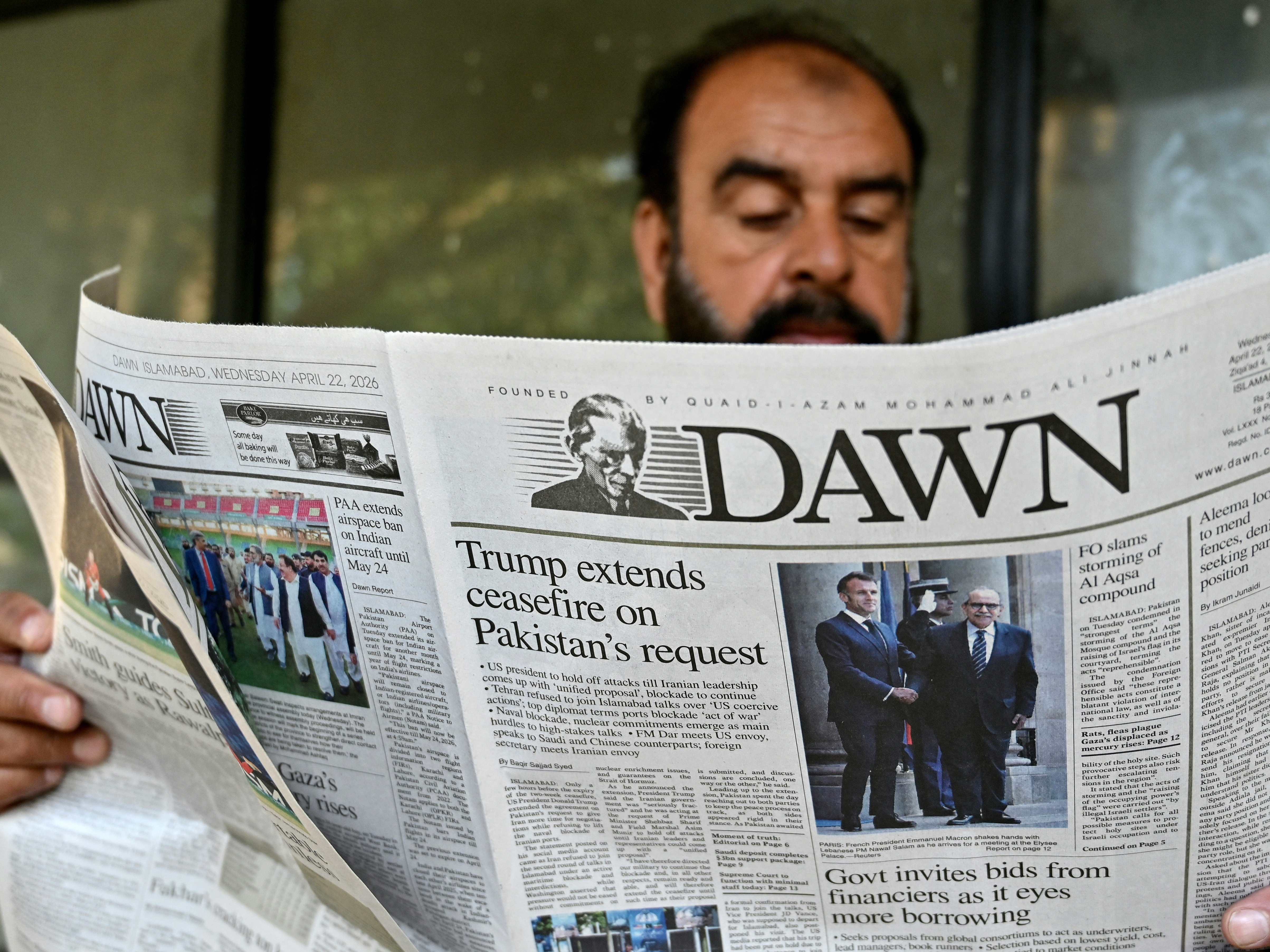 caption: A man reads a newspaper with a front page article referring to anticipated U.S.-Iran peace talks, at a stall in Islamabad on Wednesday. Pakistani Prime Minister Shehbaz Sharif thanked President Trump for extending a ceasefire with Iran and indefinitely pushing back the end of the two week truce.