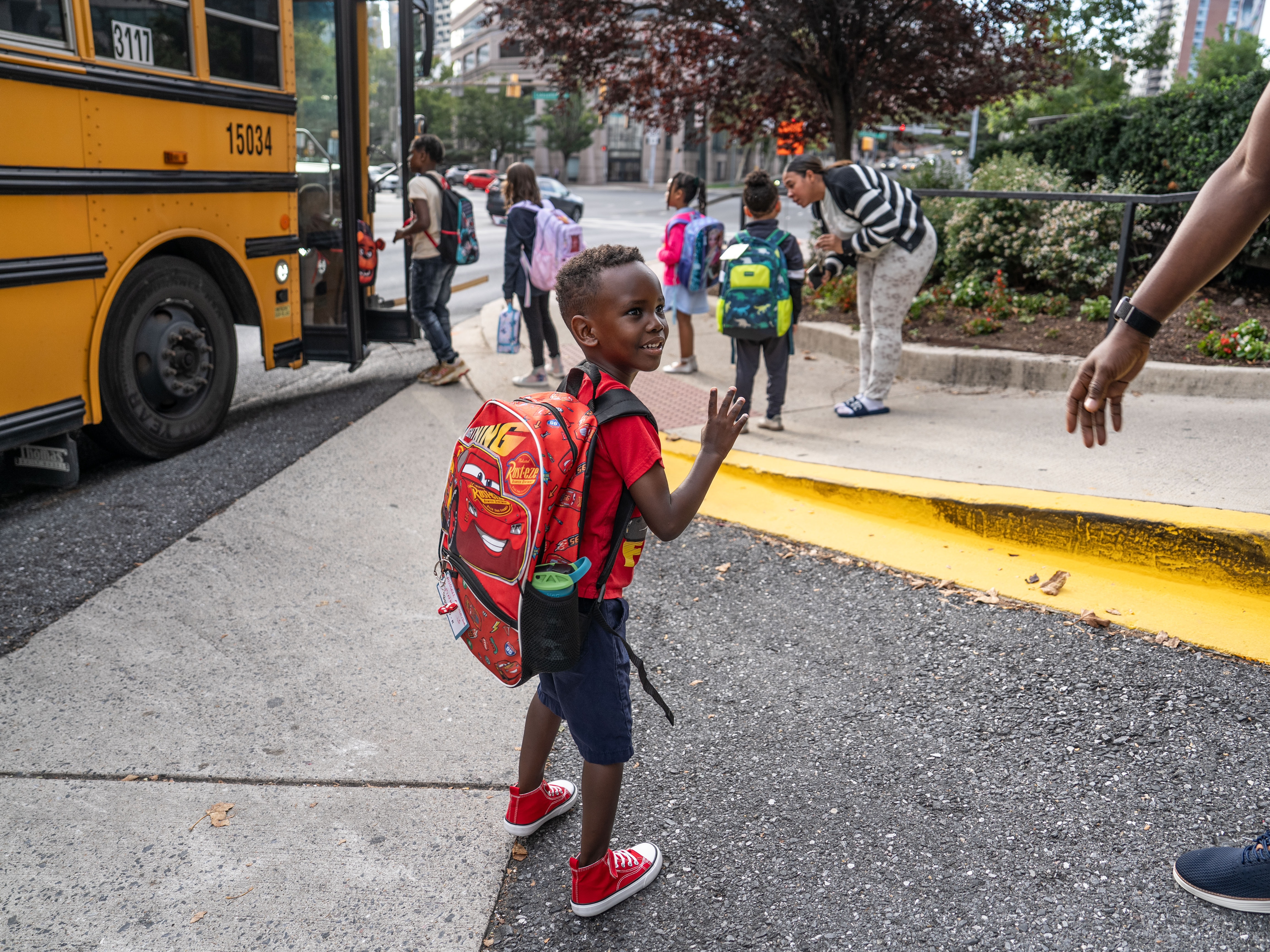 caption: Russell Siima, who started his first year of kindergarten at a public school in Montgomery County, Md., this week, waves goodbye to his parents. The milestone gave his dad a flashback to his own start of school in Uganda.
