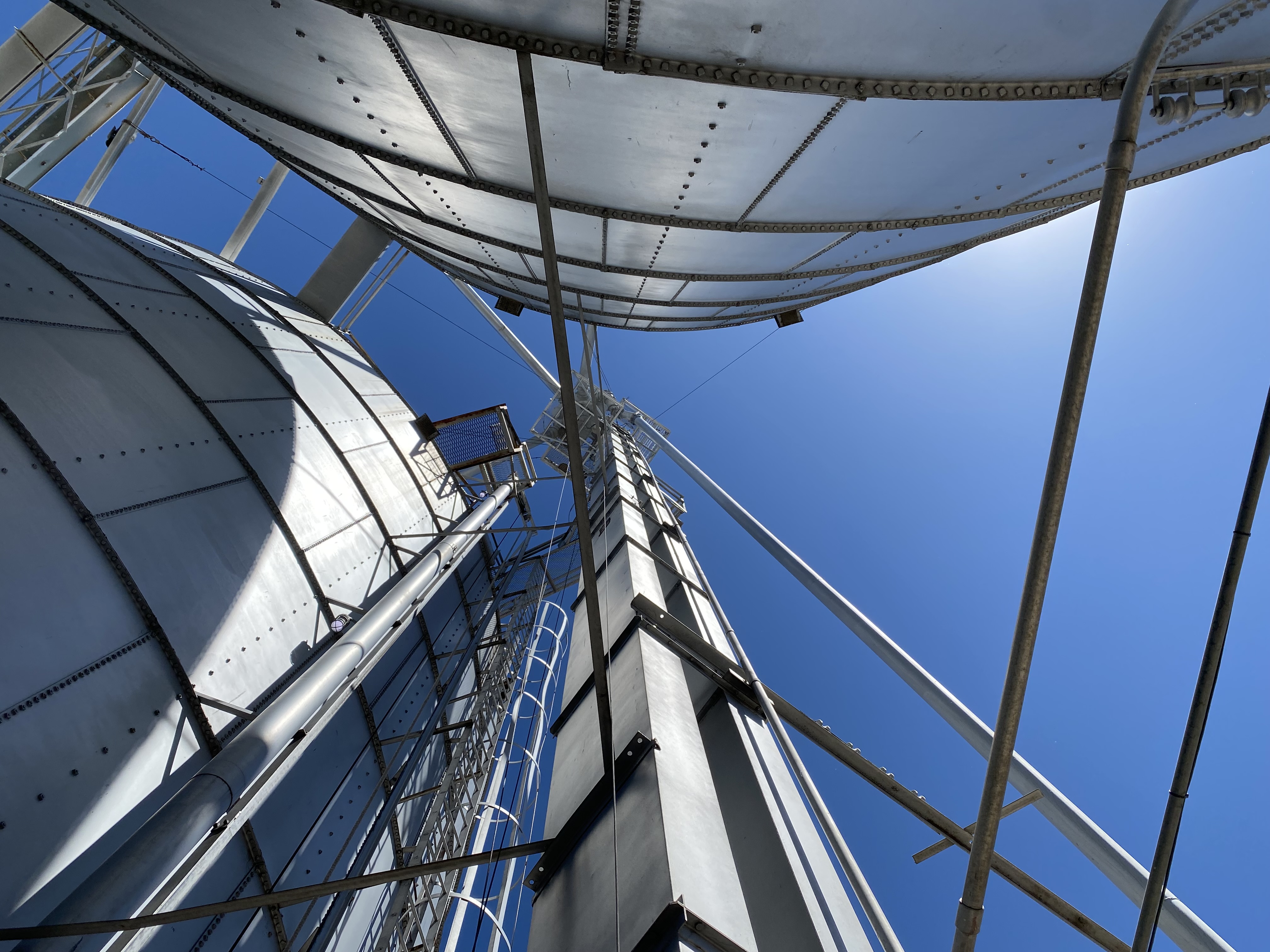 caption: A mechanism that shuttles grain, called a leg, spires into the sky amid the bins at Northwest Grain Growers in Walla Walla. The leg carries grain dumped from trucks into receiving pits, up in buckets, sometimes well over 100 feet before the grain gets distributed to the many different grain bins and storage facilities.