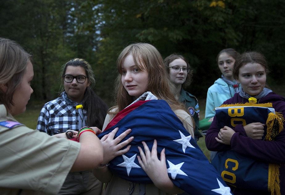 Abigail Matthews, 13, has help from Moriko Peterson, 13, left, after a flag ceremony during the Boy Scouts of America Bootcamp for girls on Saturday, October 6, 2018, at Camp Thunderbird in Olympia.