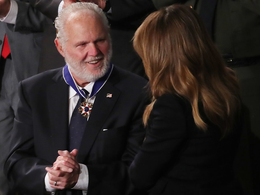 caption: Rush Limbaugh says he intends to keep putting on his radio show despite his stage 4 lung cancer that he says has recently progressed. Here, he's seen reacting as first lady Melania Trump gives him the Presidential Medal of Freedom during the State of the Union address in February.