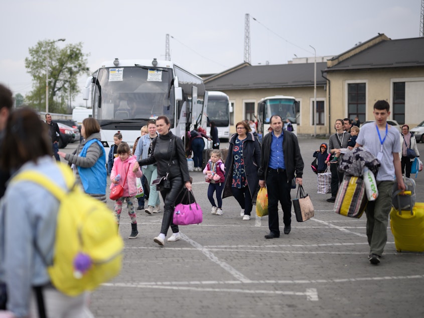 caption: Refugees from war-torn regions of Ukraine board a coach to Warsaw at a coach station on Saturday in Lviv, Ukraine. A U.N. agency estimates that nearly 5 million jobs have been lost in Ukraine since Russia first invaded in late February.