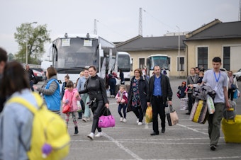 caption: Refugees from war-torn regions of Ukraine board a coach to Warsaw at a coach station on Saturday in Lviv, Ukraine. A U.N. agency estimates that nearly 5 million jobs have been lost in Ukraine since Russia first invaded in late February.