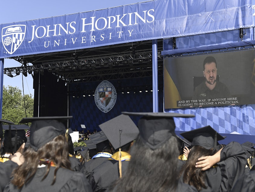 caption: Ukrainian President Volodymyr Zelenskyy addresses the graduating class of Johns Hopkins University via livestream from Ukraine on Thursday in Baltimore.