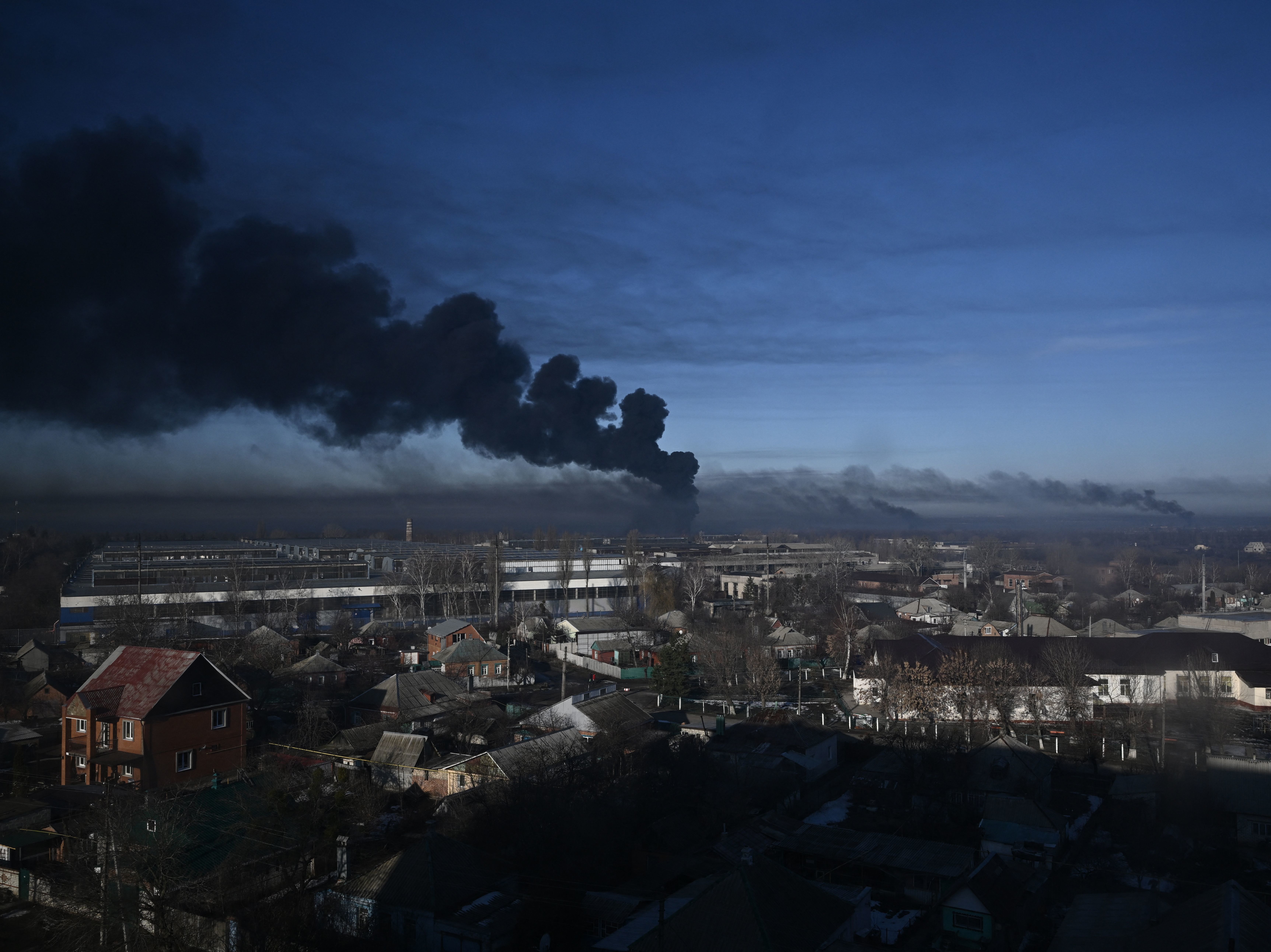 caption: Black smoke rises from a military airport in Chuguyev near Kharkiv on February 24, 2022. - Russian President Vladimir Putin announced a military operation in Ukraine today with explosions heard soon after across the country and its foreign minister warning a "full-scale invasion" was underway.
