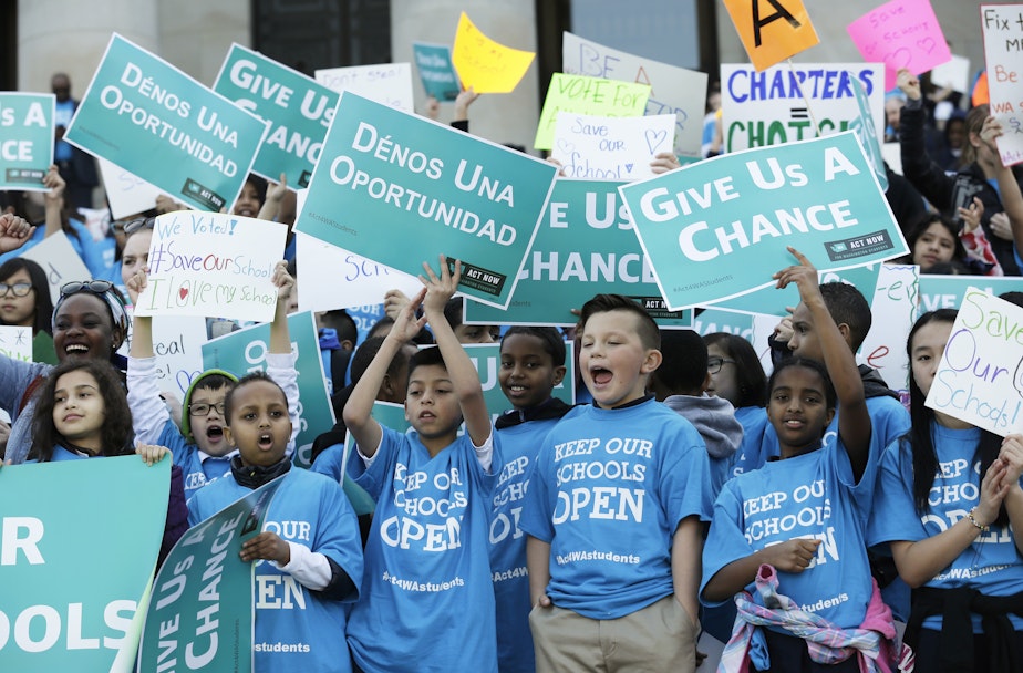 caption: FILE - In this Feb. 25, 2016, file photo, children hold signs during a rally in support of public charter schools at the Capitol in Olympia, Wash.