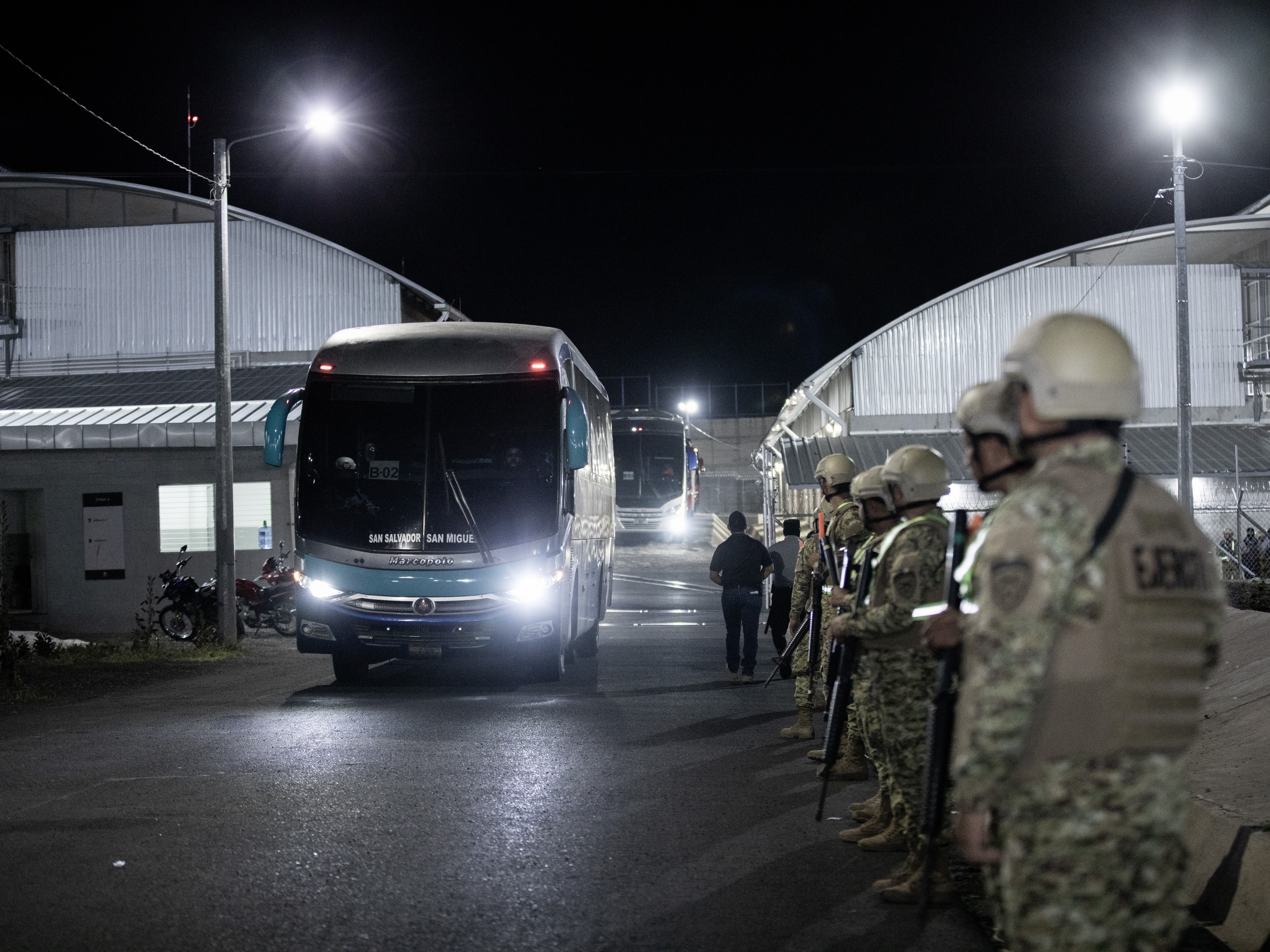 caption: Venezuelan migrants accused by the U.S. of belonging to the Tren de Aragua criminal gang are seen being transferred from the Terrorism Confinement Center (Cecot) in El Salvador before being repatriated to Caracas on July 18, 2025 in La Paz, El Salvador.