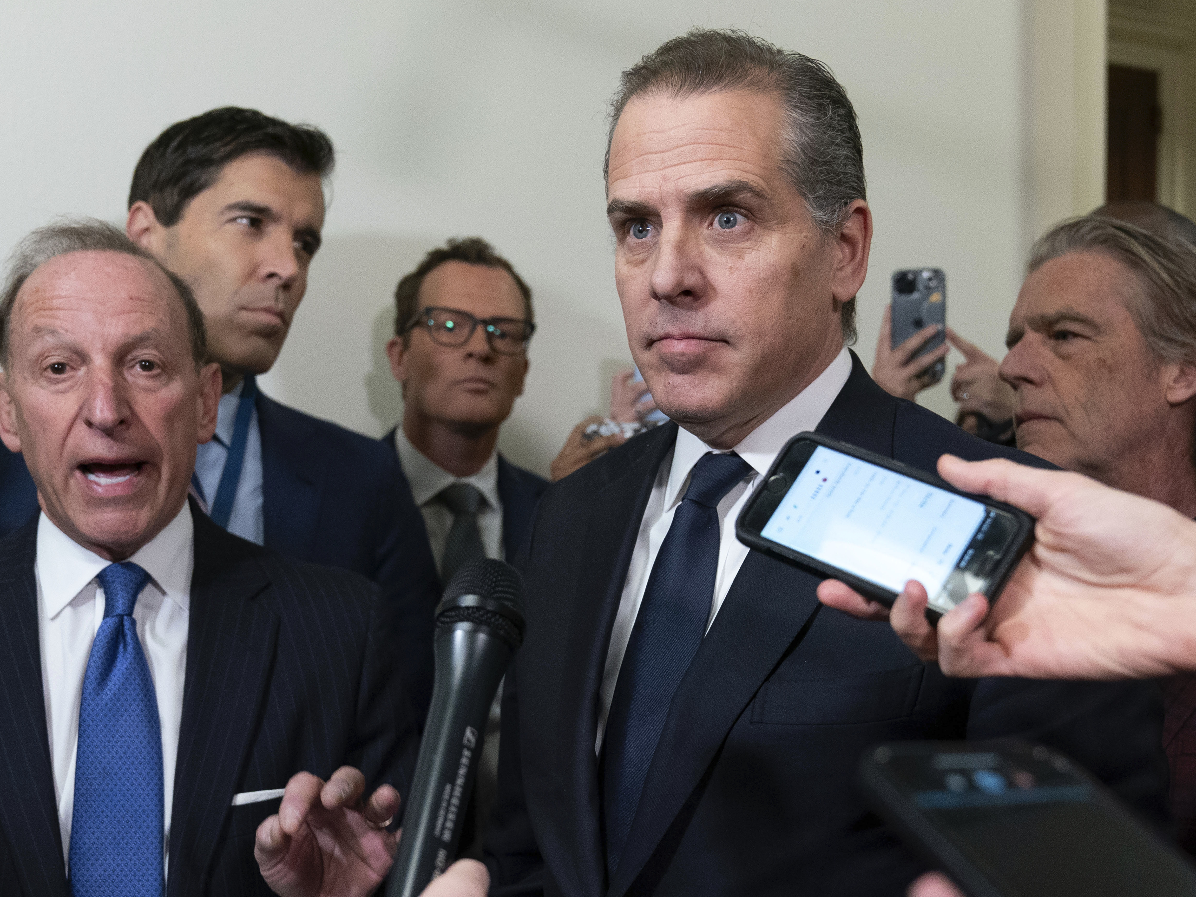 caption: Hunter Biden, President Joe Biden's son, accompanied by his attorney Abbe Lowell, left, talks to reporters as they leave a House Oversight Committee hearing as Republicans are taking the first step toward holding him in contempt of Congress, Wednesday, Jan. 10, 2024, on Capitol Hill in Washington.