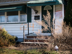 caption: A home in the Lost Valley area of Manville, N.J. The numbers spray-painted on the front of the house indicate that it was bought as part of a federal disaster program.