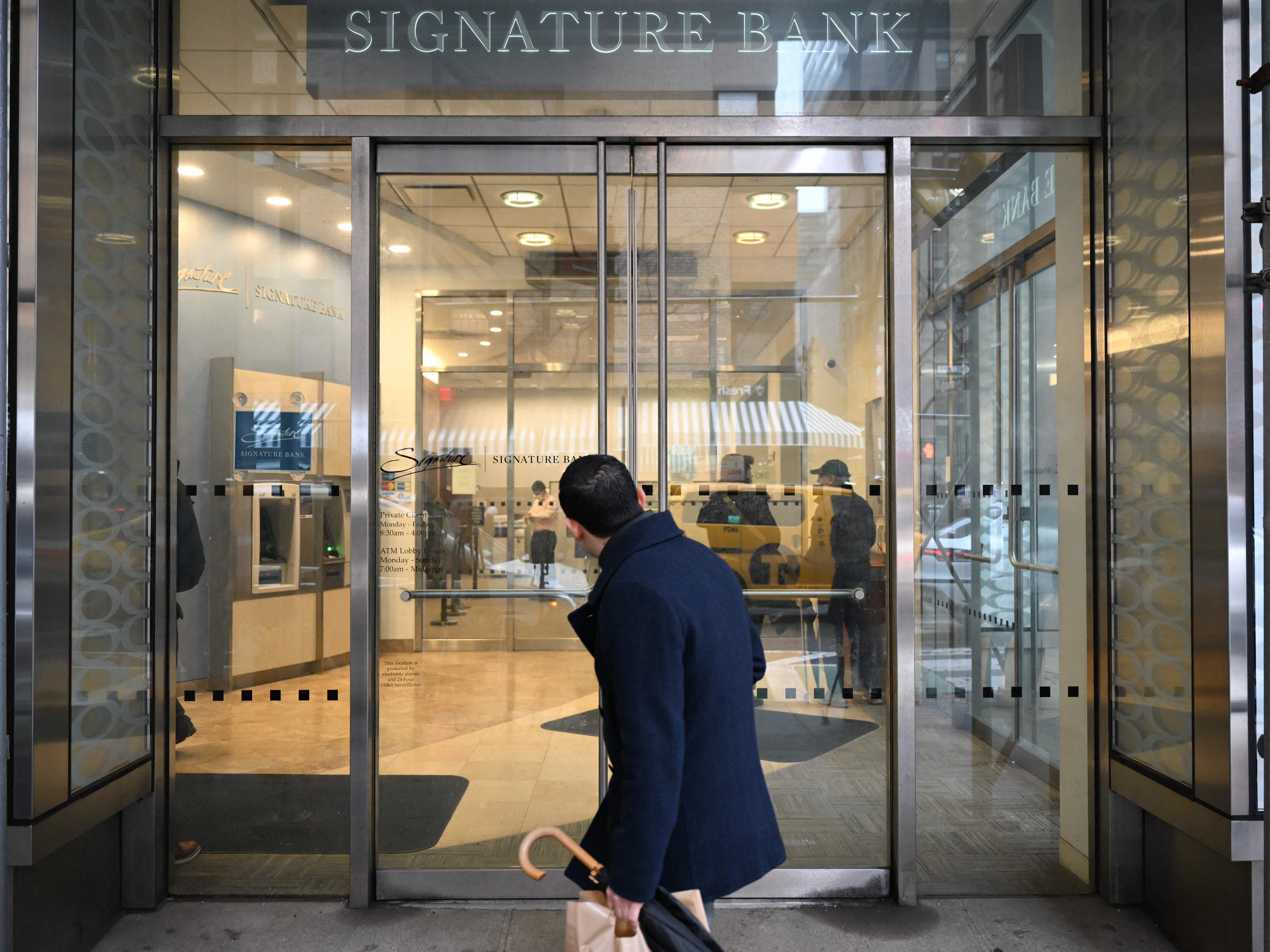 caption: A man walks past a branch of Signature Bank in New York City on March 13, 2023. After Signature Bank collapsed during the 2023 regional banking crisis, the Federal Deposit Insurance Corp. said it didn't have enough qualified examiners to catch the problems that had led to the bank's failure.