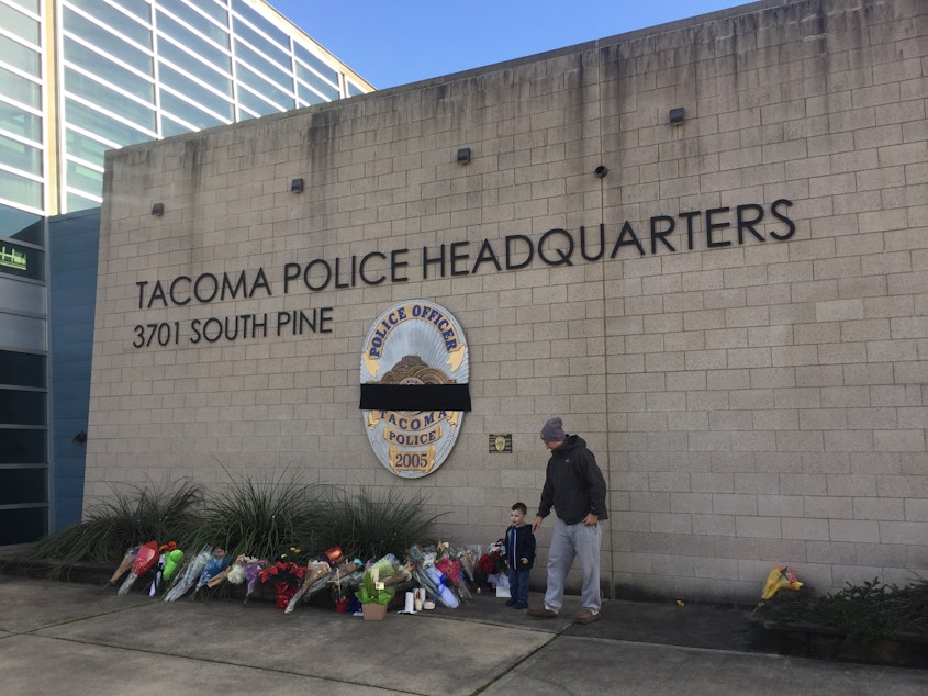 caption: Chris Kerns and his son, Nolan, laid flowers in honor of the fallen Tacoma police officer on Thursday.