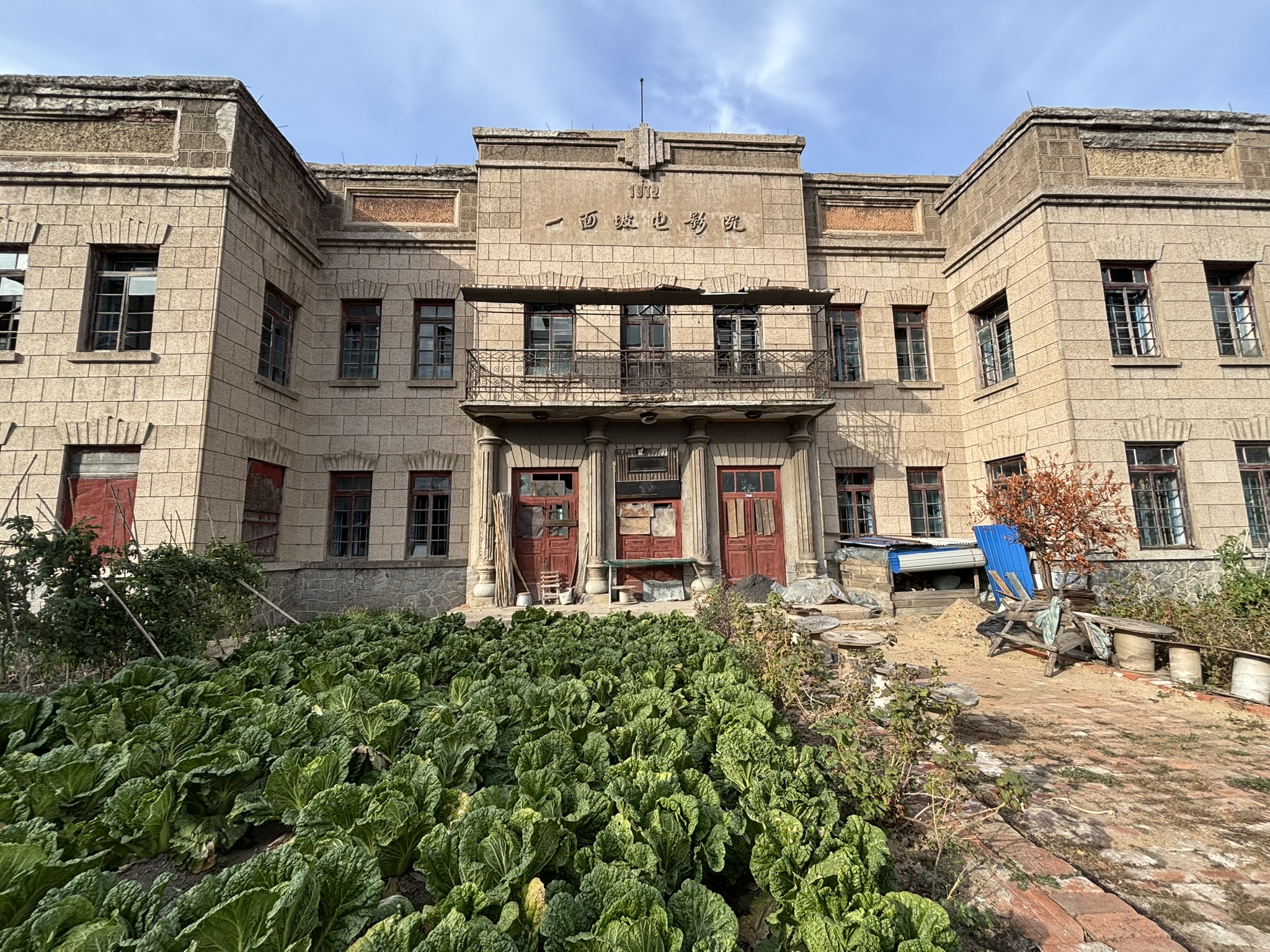 caption: Vegetables grow in front of an abandoned movie theater in Yimianpo, in China's northeastern Heilongjiang Province.