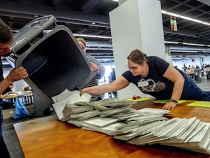 caption: Elections workers empty a bin to count postal ballots for the European Union elections in Frankfurt, Germany, on Sunday, June 9, 2024.