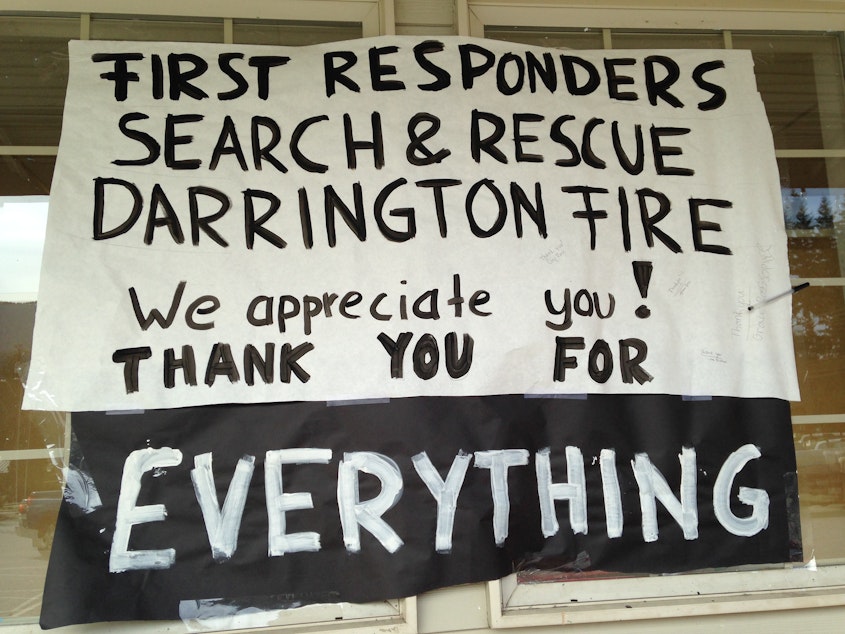 caption: A hand-lettered sign outside Darrington's grocery store thanks rescue workers.