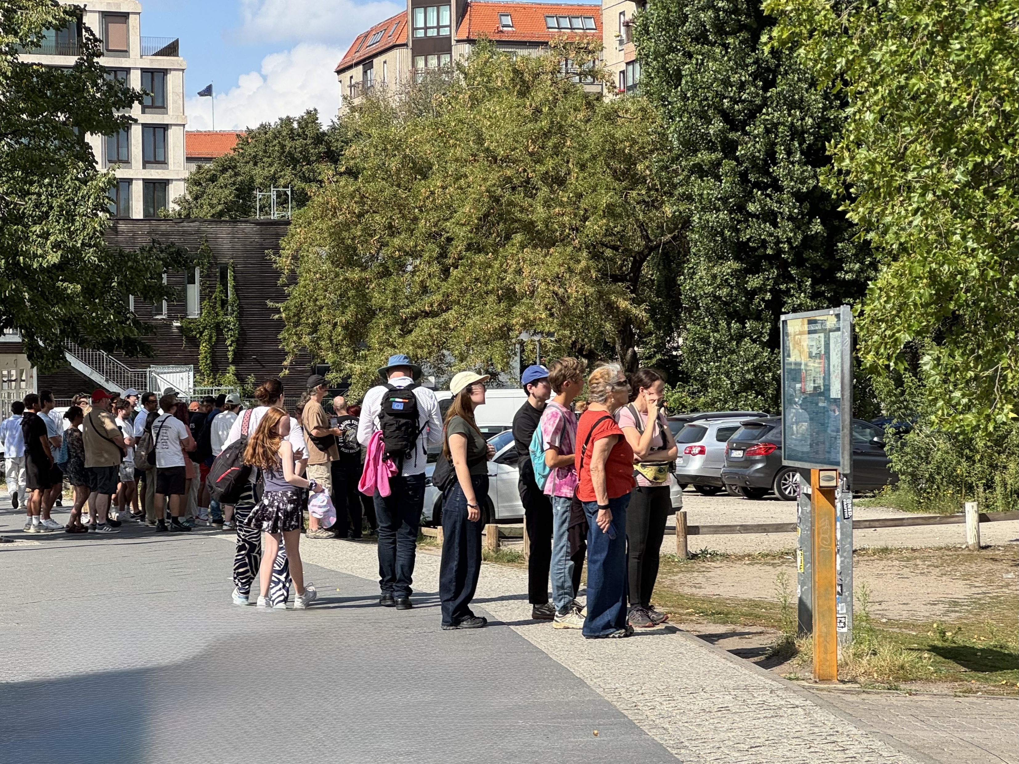 caption: Tourists gather at a parking lot in the center of Berlin, Germany.