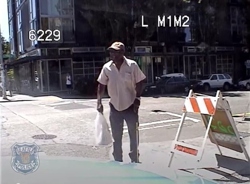 caption: In this screenshot from a video provided by the Seattle Police Department, William Wingate is seen using a golf club like a cane when confronted by Officer Cynthia Whitlatch on July 9, 2014, in Seattle.