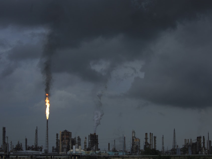 caption: A gas flare from the Shell Chemical LP petroleum refinery illuminates the sky on Aug. 21 in Norco, La.