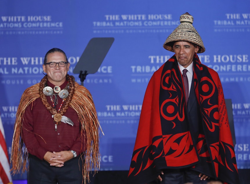 caption: President Barack Obama wears a blanket and hat given to him by Brian Cladoosby, left, President of National Congress of American Indians, during the 2016 White House Tribal Nations Conference, Monday, Set. 26, 2016.