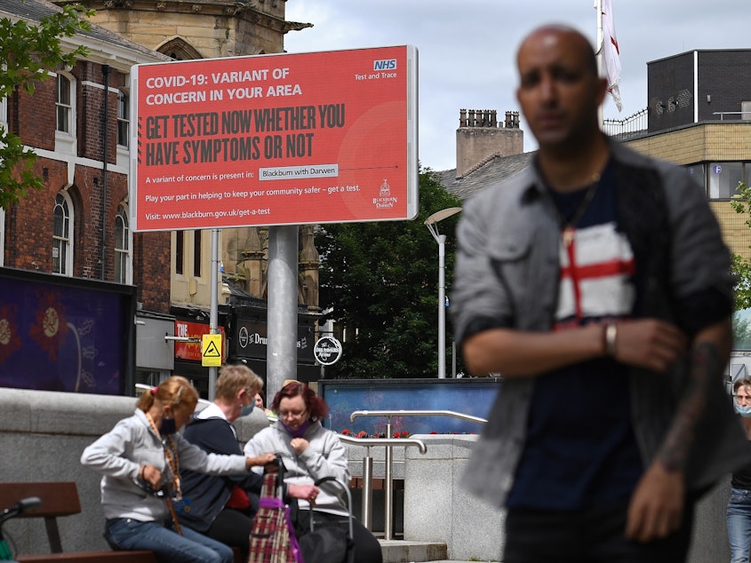 caption: A sign urges people to get tested for a COVID-19 variant in Blackburn, England. The U.K. is experiencing a surge in the Delta variant, which was first identified in India.