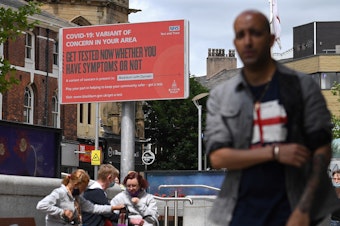 caption: A sign urges people to get tested for a COVID-19 variant in Blackburn, England. The U.K. is experiencing a surge in the Delta variant, which was first identified in India.
