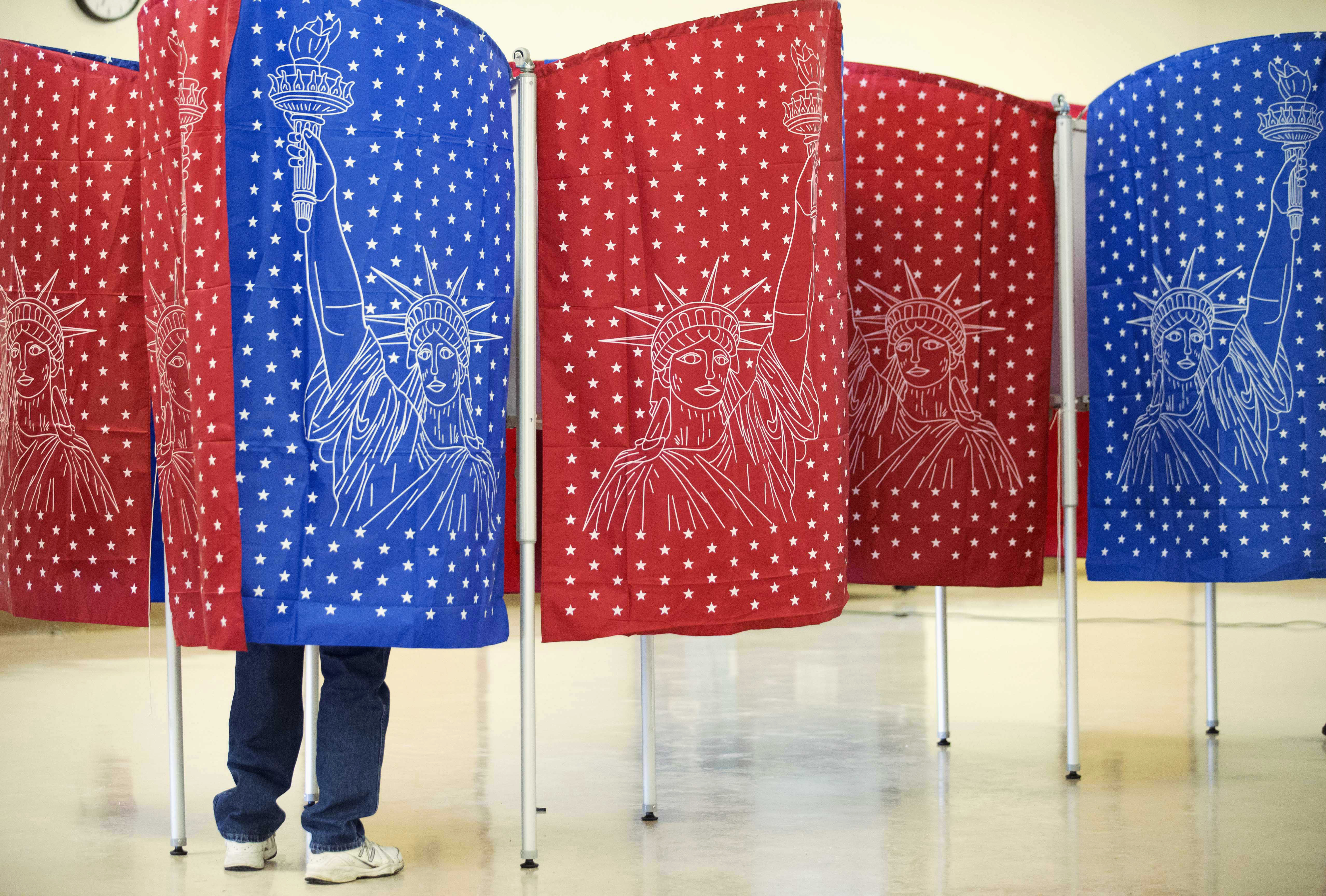 caption: A voter marks a ballot for the New Hampshire primary inside a voting booth at a polling place Tuesday, Feb. 9, 2016, in Manchester, N.H.
