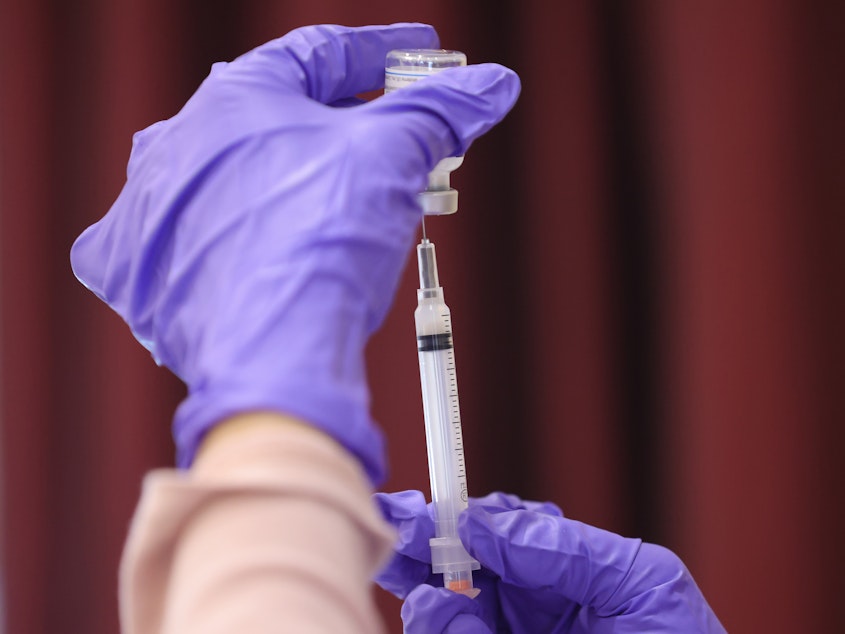 caption: A nurse draw a Moderna COVID-19 vaccine dose from a vial at the Cameron Grove Community Center in Bowie, Md., in late March. Moderna says study data supports use of a half-dose of the vaccine in children 6 to 11.