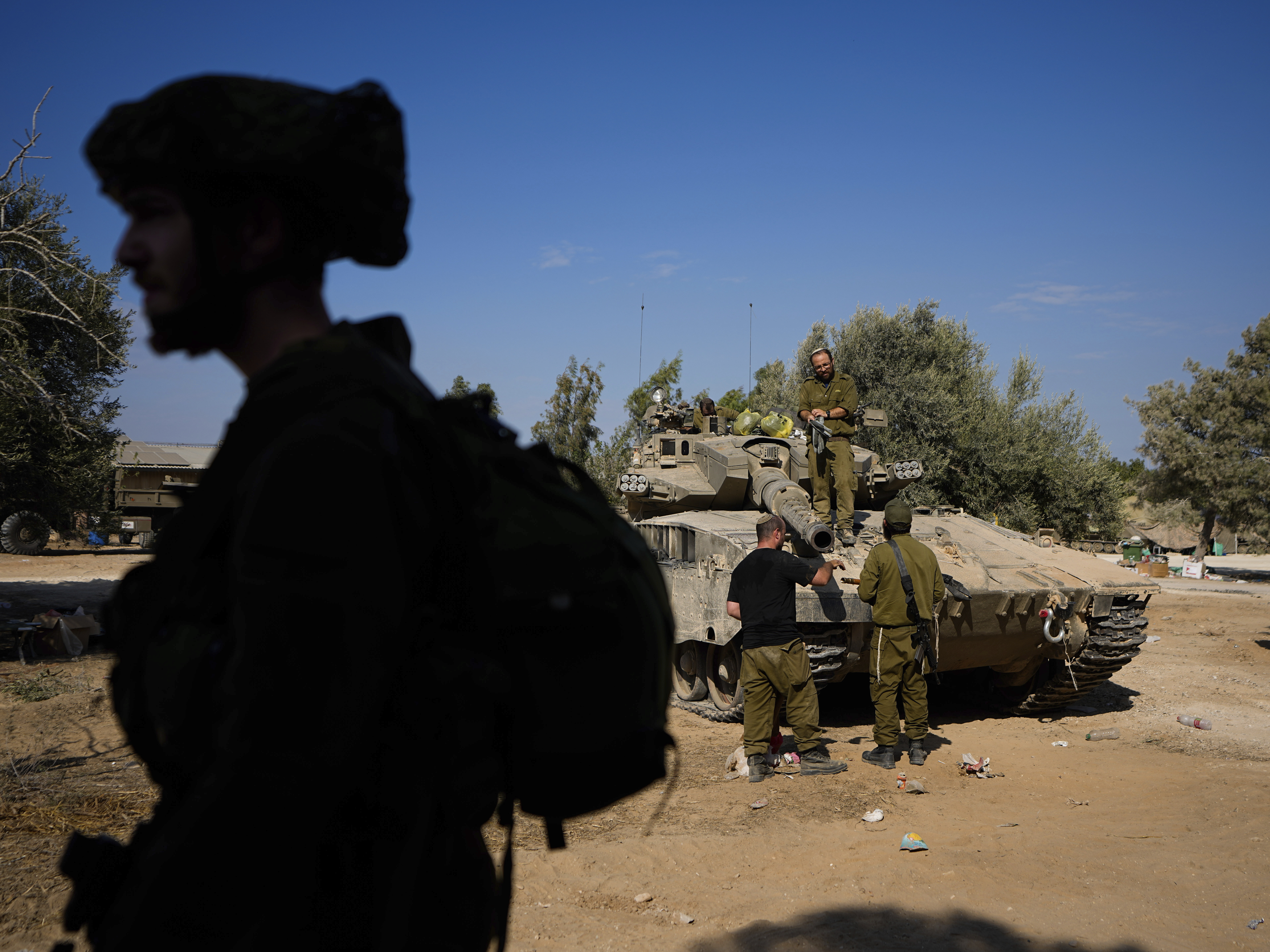 caption: Israeli soldiers gather in a staging area near the border with Gaza Strip, in southern Israel Tuesday.
