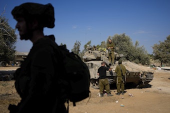caption: Israeli soldiers gather in a staging area near the border with Gaza Strip, in southern Israel Tuesday.