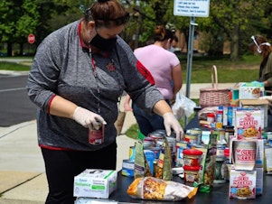 caption: Volunteers for the grassroots network Columbia Community Care organize donated groceries and household items at one of five distribution sites in Howard County, Maryland.