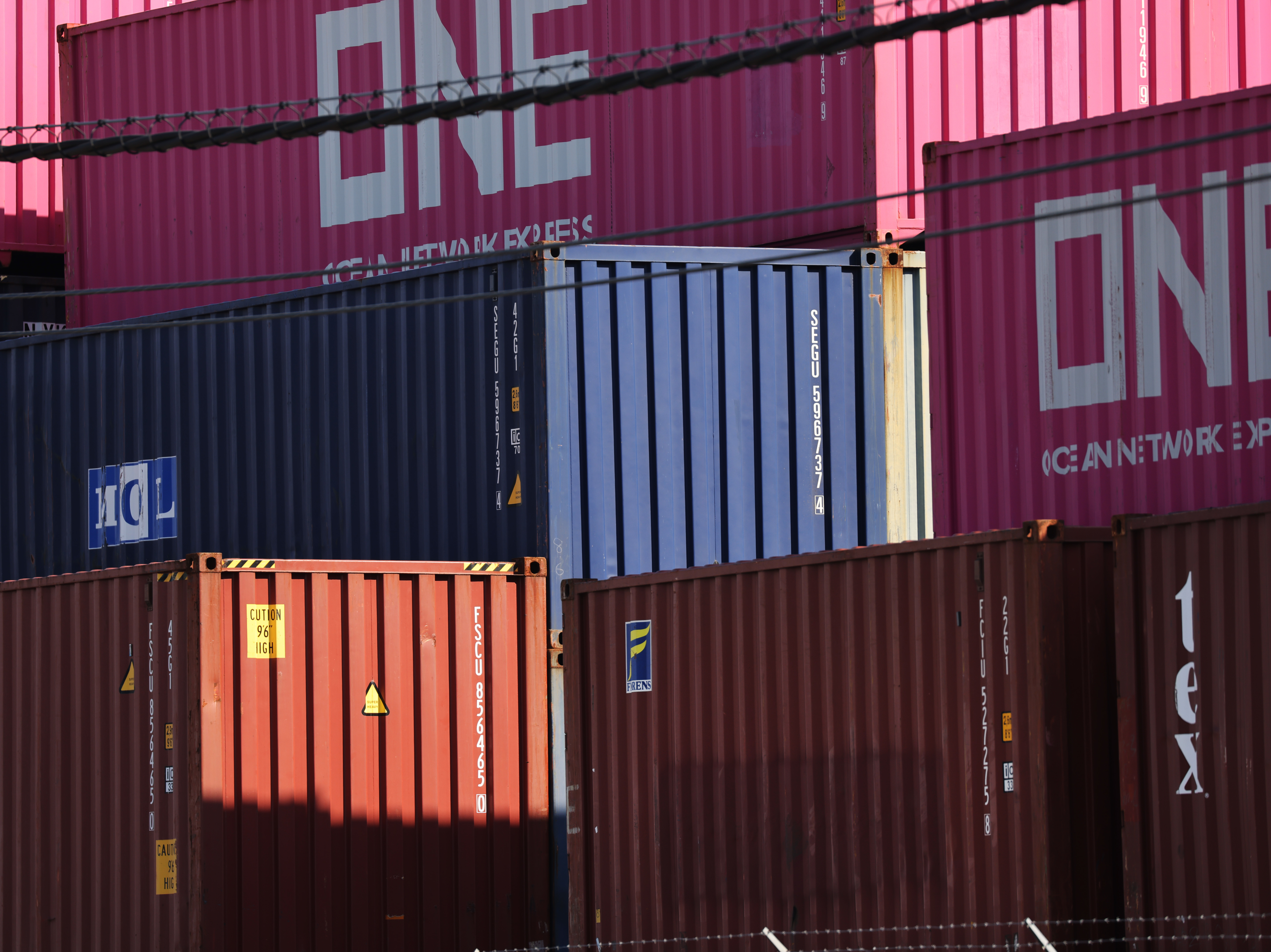 caption: Shipping containers sit stacked at a port in Bayonne, N.J., on Oct. 15. Supply chain problems are disrupting the global economy, causing delays and a shortage of containers.