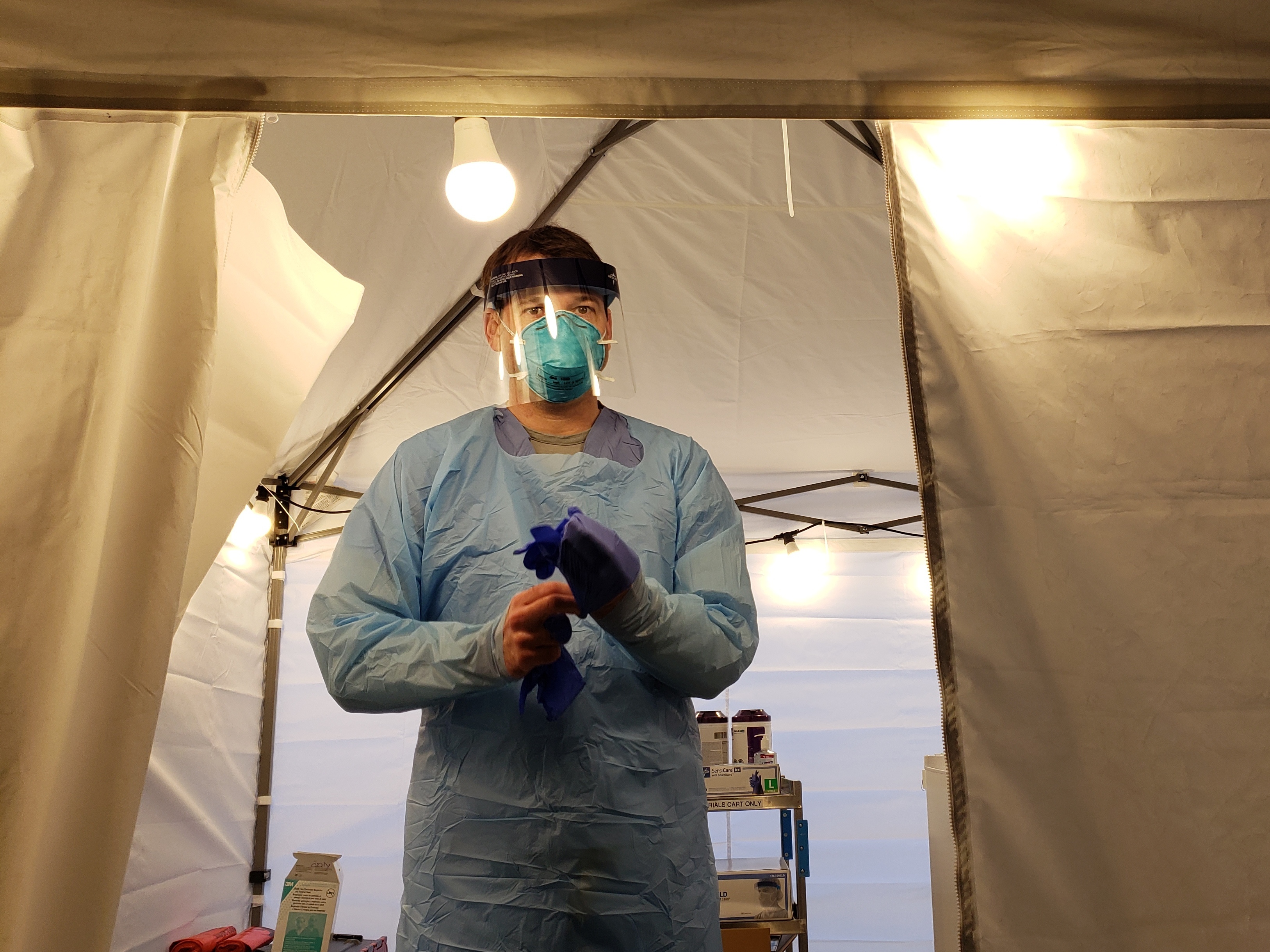 caption: Nurse Jeff Gates prepares to assess another patient in UW Medicine's drive-through coronavirus testing clinic in Seattle.