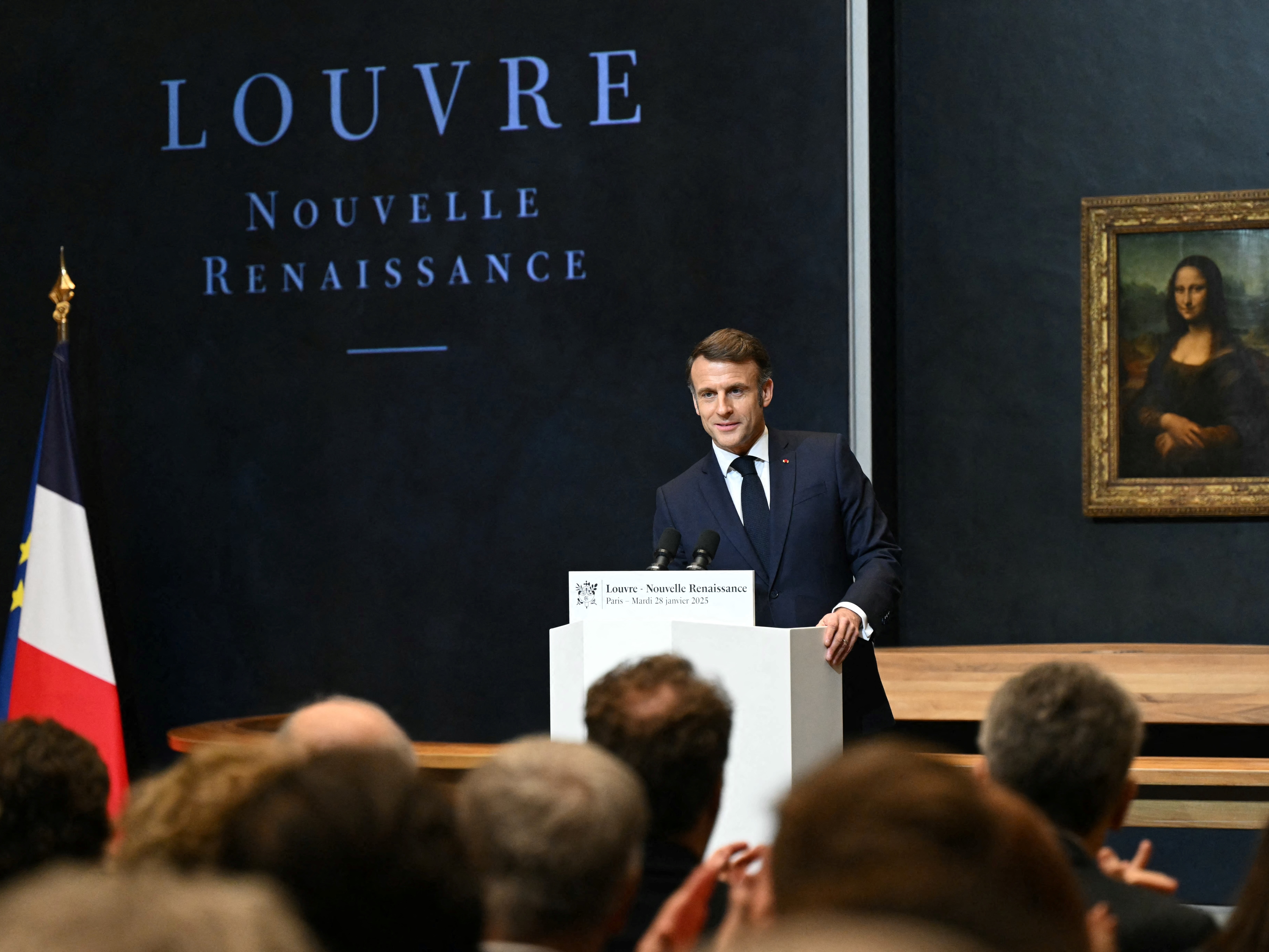 caption: French President Emmanuel Macron gives a speech in front of the <em>Mona Lisa</em> by Leonardo da Vinci at the Louvre in Paris on Tuesday.
