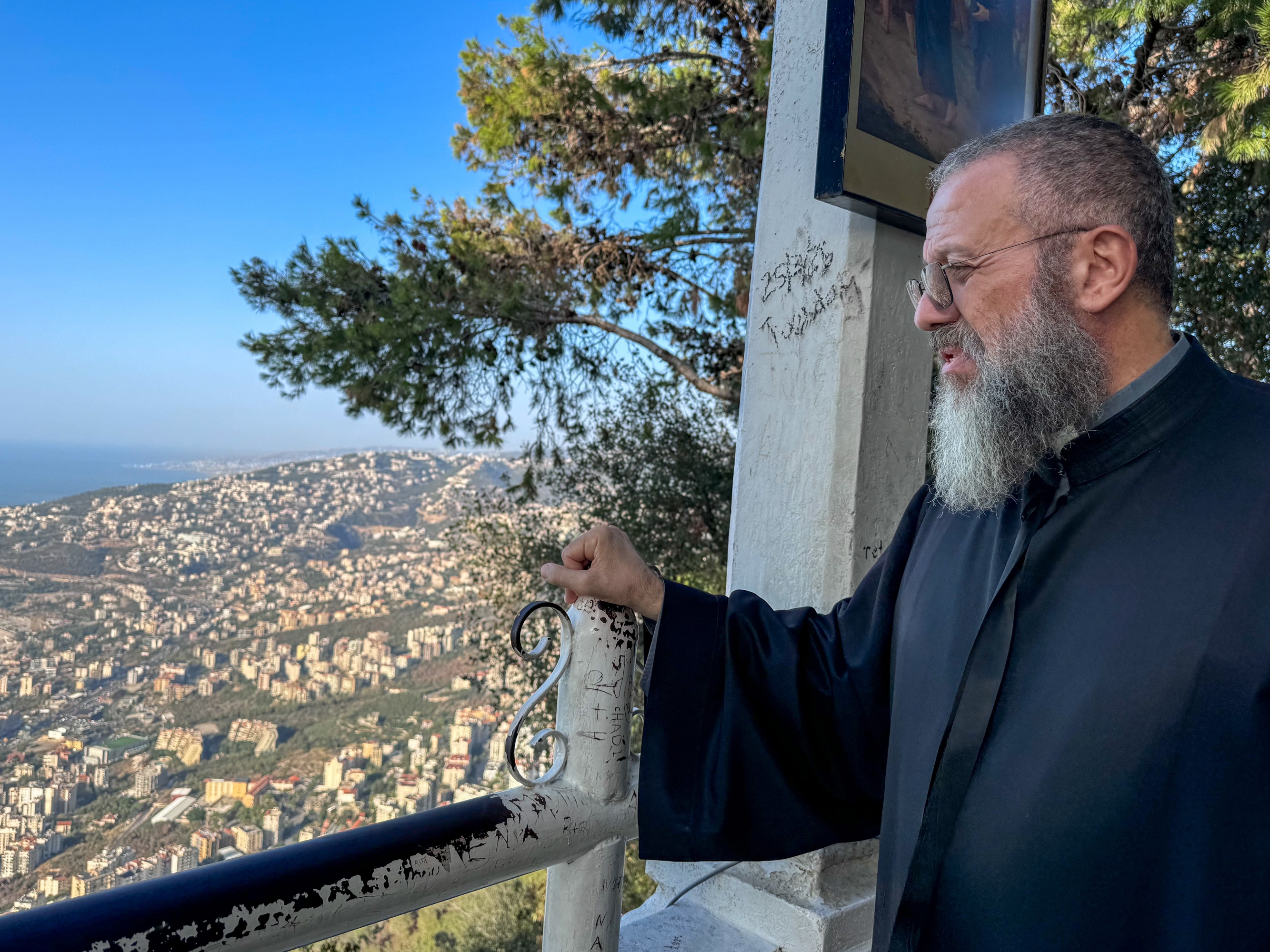caption: Father Fadi el-Mir looks out to the Mediterranean from Our Lady of Lebanon sanctuary. Pope Leo will meet there with clergy and other church officials.