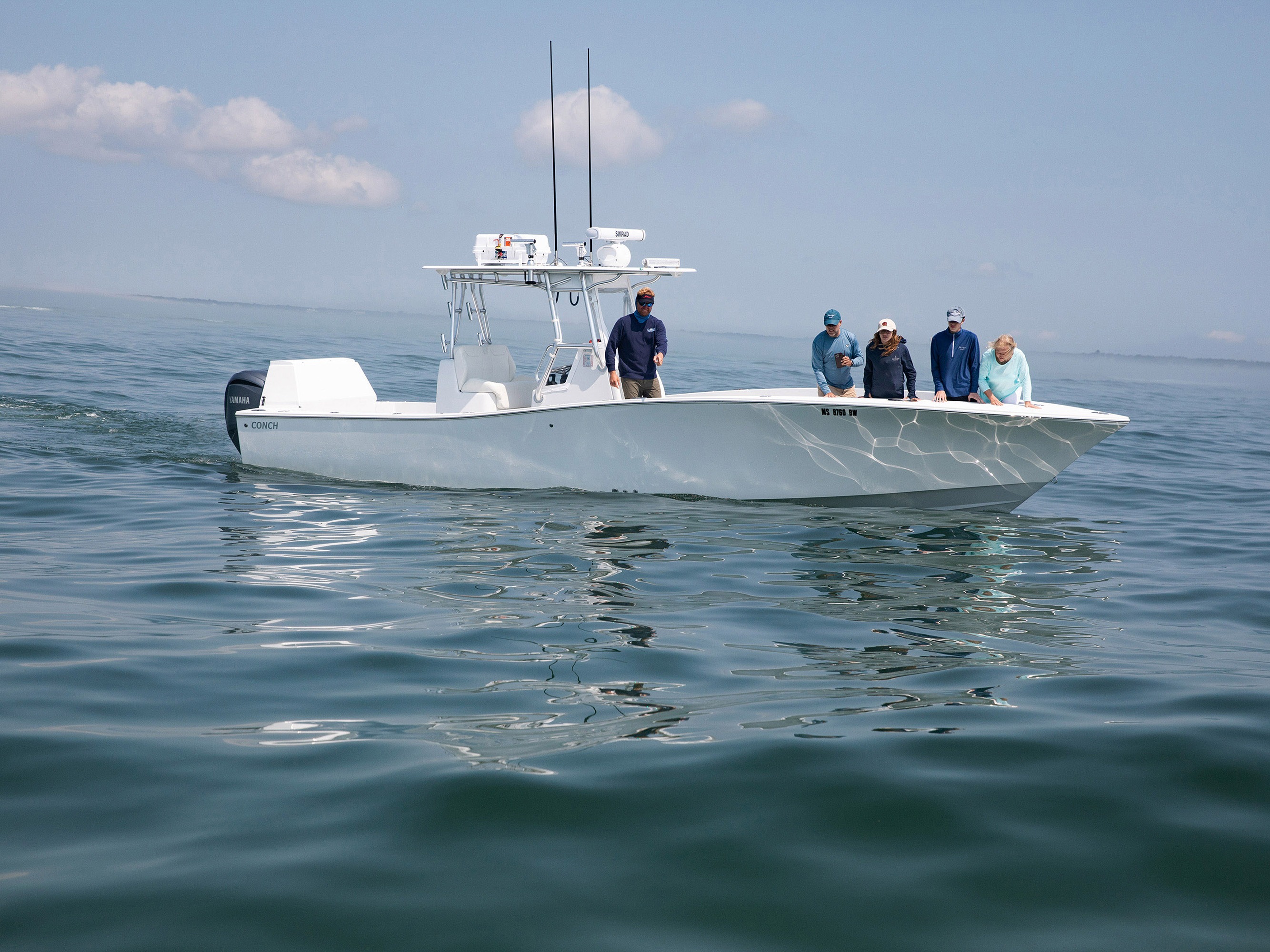 caption: Great white shark tours have become popular around Cape Cod as more of the largest predator fish are showing up here. Captain Cullen Lundholm (left) of White Sharks Tours Cape Cod points to a 12-foot female shark as passengers of a private charter try to spot it. Tours like this are pricey as companies use spotter planes to find the great whites.  A private tour on a charter boat can costs $2,000 dollars or more, while group tours are around $300 per person. 