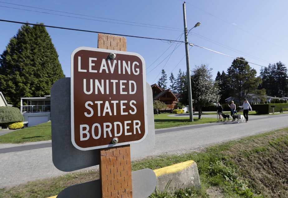 caption: Sign posted at the U.S.-Canada border.
